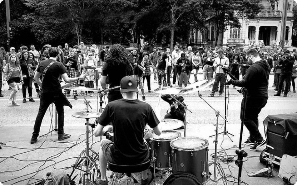 Show ao ar livre em preto e branco, com o público ao redor