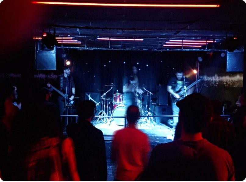 Banda no palco sob luz vermelha e azul